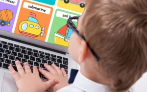 Young child learning phonics on a laptop with colorful flashcards — Reading Head Start program for early literacy development